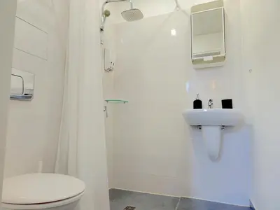 a white bathroom with a toilet and a sink at Antim Boutique Apartments in Sofia