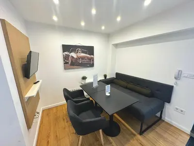 a living room with a couch and a table and chairs at Antim Boutique Apartments in Sofia