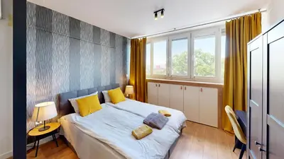 a bedroom with a large bed with yellow pillows at Modern City Stay apartment 4 min walk from Alexander Nevski in Sofia