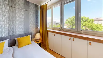 a bedroom with a bed and two windows at Modern City Stay apartment 4 min walk from Alexander Nevski in Sofia