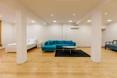 a living room with a blue couch and a bed at Saffron Guest House in Plovdiv