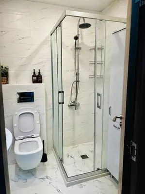 a bathroom with a toilet and a glass shower at Malinova Stylish Apartment in Sofia