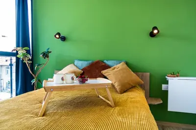 a green bedroom with a bed with a tray on it at Artistic Flat in City Center for Business&Pleasure Trips in Sofia
