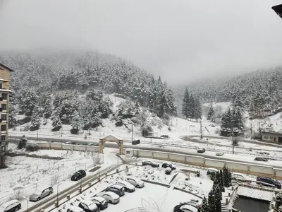 a snow covered mountain with cars parked in a parking lot at Студио Бети Балнео Спа Хотел Свети Спас in Velingrad