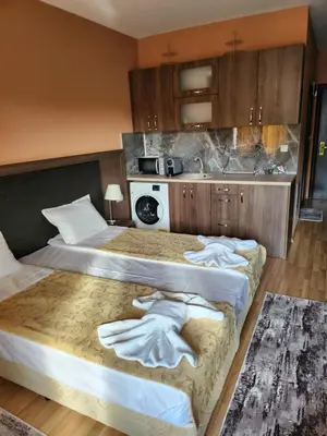 two beds in a hotel room with towels on them at Студио Бети Балнео Спа Хотел Свети Спас in Velingrad