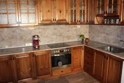 a kitchen with wooden cabinets and a sink and a stove at Delchevata Kushta V Leshten in Leshten