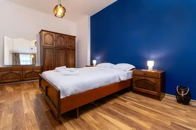 a bedroom with a large bed and a blue wall at City Center Retro Chic Kapana 2-Bed Apartment in Plovdiv
