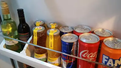 a refrigerator filled with cans and bottles of soda at Modern Comfort near Airport, The Mall, TechPark by KeyBox in Sofia