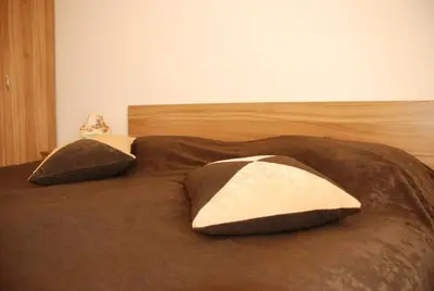 a bed with two pillows on top of it at Едноспален апартамент Pirin Palace in Bansko