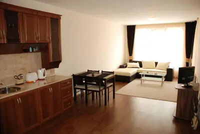 a kitchen and living room with a table and chairs at Едноспален апартамент Pirin Palace in Bansko