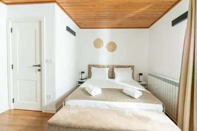 a bedroom with a large bed with a wooden ceiling at Apart house EMA 4 in Bansko