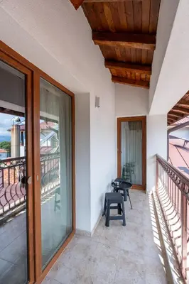 a balcony with sliding glass doors and a bench on a patio at Apart house EMA 4 in Bansko
