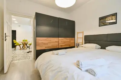 a bedroom with a large white bed with two towels at Apart Hotel Roma in Sofia
