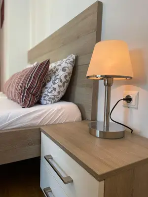 a bedroom with a bed with a lamp on a desk at The Central Post Apartments in Sofia