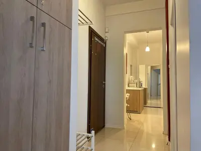 a hallway with a door leading to a kitchen at The Central Post Apartments in Sofia