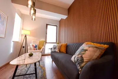 a living room with a couch and a table at Апартамент за гости Асеновец in Asenovgrad
