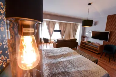 a bedroom with a bed and a living room at Апартамент за гости Асеновец in Asenovgrad