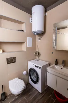 a bathroom with a washing machine and a toilet at Central & Quiet 2BR with Free Private Parking in Sofia