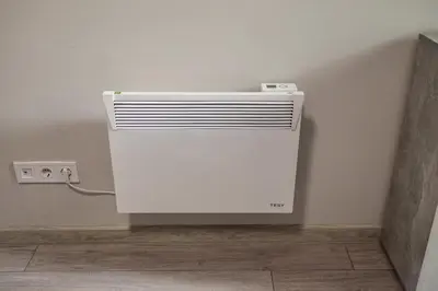 a white heater in a corner of a room at Modern 1BR Comfort in Oborishte with Private Parking in Sofia