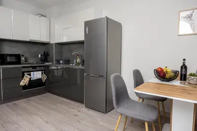a kitchen with a stainless steel refrigerator and a table at Modern 1BR Comfort in Oborishte with Private Parking in Sofia