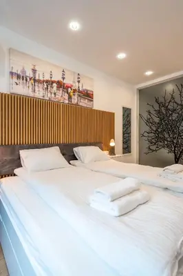 a large white bed with towels on top of it at Zenith Apartment in Sofia