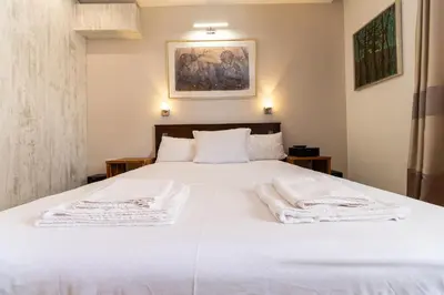 a bedroom with a white bed with towels on it at Central 1-bedroom Apartment in Plovdiv