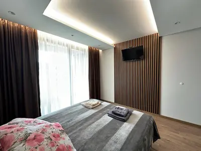 a bedroom with a bed with a television on the wall at Apartment G17 in Pernik