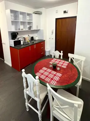 a kitchen with a red table and white chairs at Sweet Apartment Flora Violet 3 in Borovets