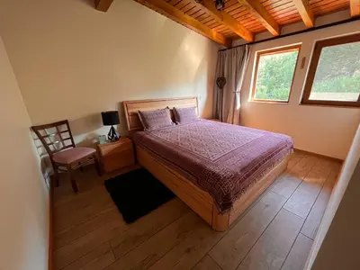 a bedroom with a bed and a chair and a window at Vista Villa at Katarino SPA in Bansko