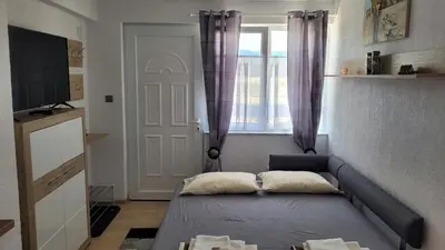 a small room with a bed and a window at Strumyani tiny flat in Sandanski