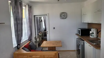 a kitchen with a couch and a table in a room at Strumyani tiny flat in Sandanski