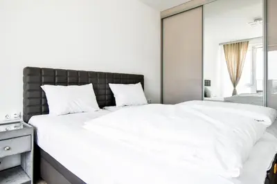 a bedroom with a large white bed with a large mirror at Nomad Friendly Modern Complex Next to Metro in Sofia