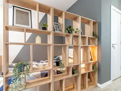 a wooden book shelf in a room with potted plants at Stay Central: Urban Studio Gem in Sofia