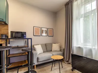 a living room with a couch and a window at Stay Central: Urban Studio Gem in Sofia