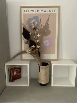 a vase with flowers in it next to two shelves at New Two Bedroom apartment with balcony in Sofia
