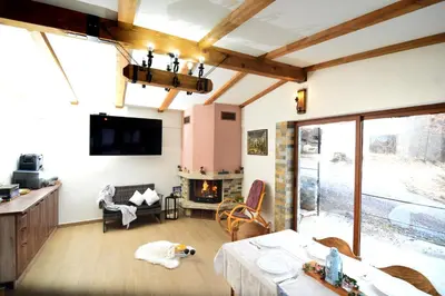 a living room with a table and a fireplace at Стаи за гости Ингилизовата къща in Padala