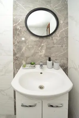 a bathroom with a white sink and a mirror at Стаи за гости Ингилизовата къща in Padala