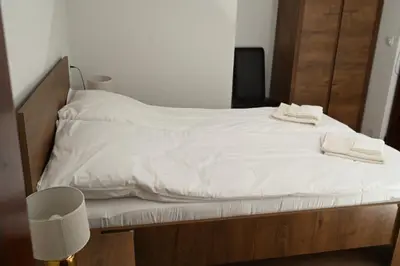 a bed with white sheets and two towels on it at Стаи за гости Ингилизовата къща in Padala