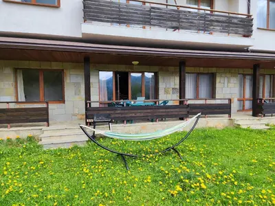 a hammock in the grass in front of a building at Panorama Stoykite Orpheus in Stoykite