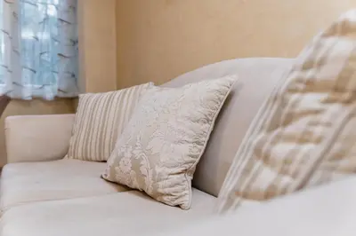 a white couch with a pillow on top of it at Elegant 1-Bedroom Apartment in Plovdiv