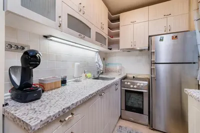 a kitchen with white cabinets and a stainless steel refrigerator at Elegant 1-Bedroom Apartment in Plovdiv