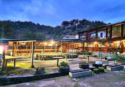 a building with a courtyard with tables and benches at Хотел Механа Воденицата in Zlatkov Chiflik