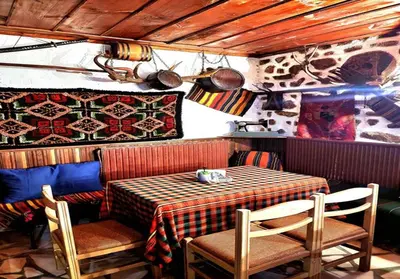 a table and chairs in a restaurant with a table and a table and chairs at Хотел Механа Воденицата in Zlatkov Chiflik