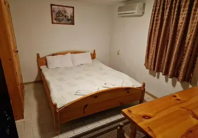 a bedroom with a wooden bed in a room at Хотел Механа Воденицата in Zlatkov Chiflik