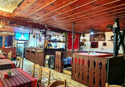 a restaurant with a bar with tables and chairs at Хотел Механа Воденицата in Zlatkov Chiflik
