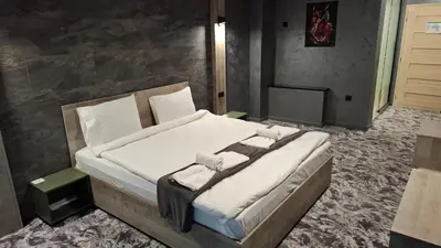 a bedroom with a large bed with white sheets at RCR Einstein studios in Sofia