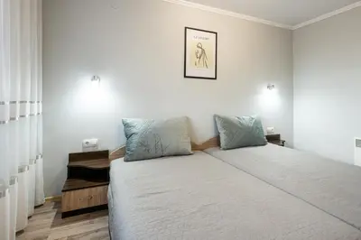 a bedroom with a large bed with two pillows at Апартамент за гости ВениАн in Velingrad