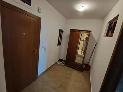 a hallway with a wooden door and a mirror at Apartment Danik River Glaznel in Bansko