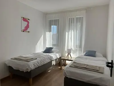 a bedroom with two beds and a window at Idea Apartment in Sofia