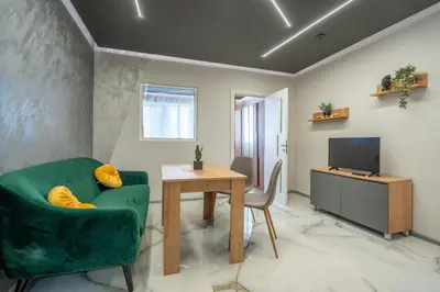 a living room with a green couch and a table and a television at Cozy Homes 4 in Sofia